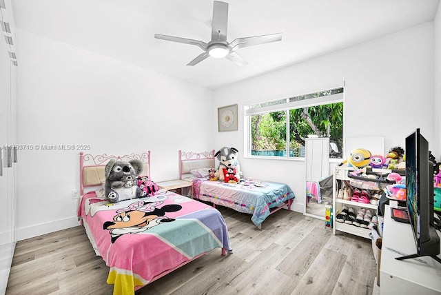 bedroom featuring baseboards, wood finished floors, and a ceiling fan