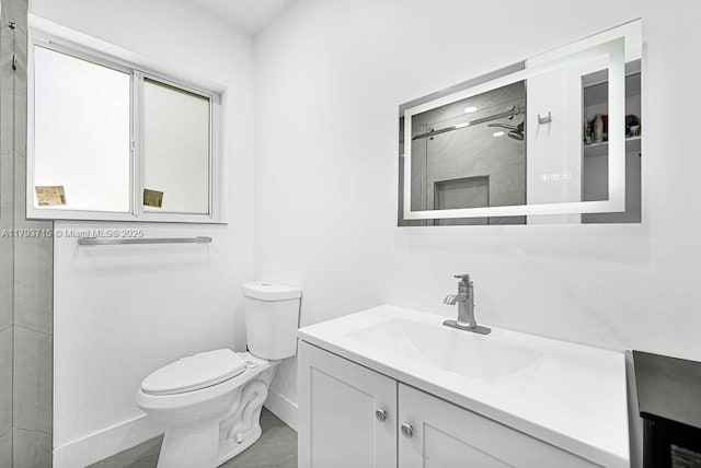 full bathroom featuring vanity, toilet, baseboards, and a shower