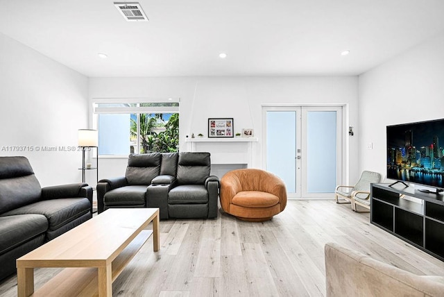 living area featuring light wood finished floors, visible vents, and recessed lighting