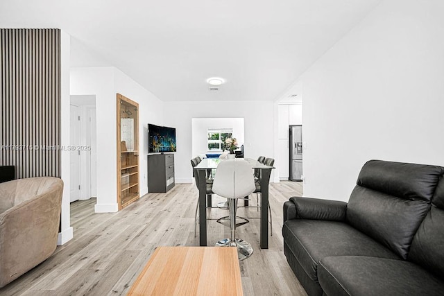 living area featuring light wood-style floors and baseboards