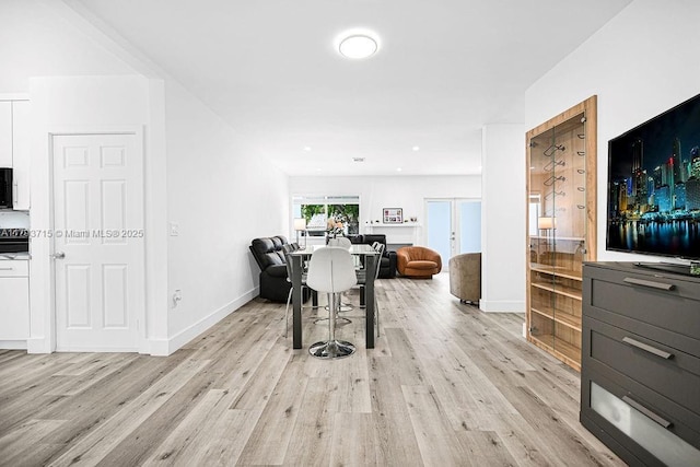 dining space featuring baseboards and light wood-type flooring