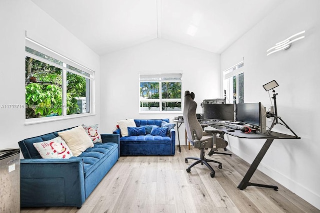 office featuring baseboards, a wealth of natural light, wood finished floors, and vaulted ceiling