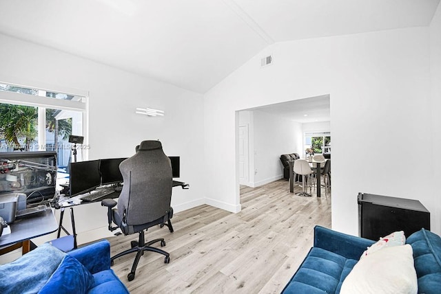 office space featuring lofted ceiling, baseboards, visible vents, and wood finished floors