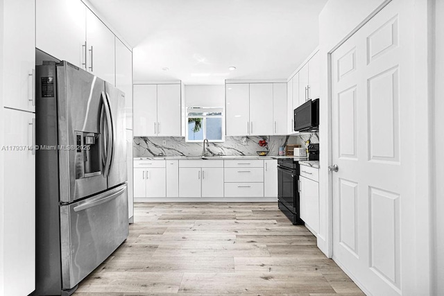 kitchen featuring light wood-style flooring, white cabinetry, black appliances, tasteful backsplash, and recessed lighting