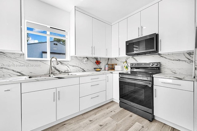 kitchen with white cabinetry, backsplash, appliances with stainless steel finishes, and a sink