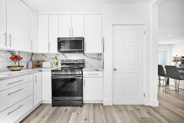 kitchen featuring white cabinetry, light countertops, light wood finished floors, and appliances with stainless steel finishes