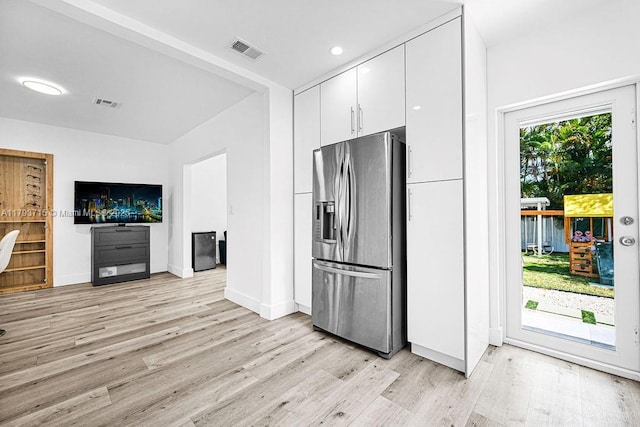 kitchen featuring stainless steel fridge with ice dispenser, white cabinetry, visible vents, and light wood finished floors