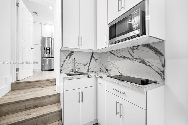 kitchen featuring a sink, white cabinetry, visible vents, appliances with stainless steel finishes, and tasteful backsplash