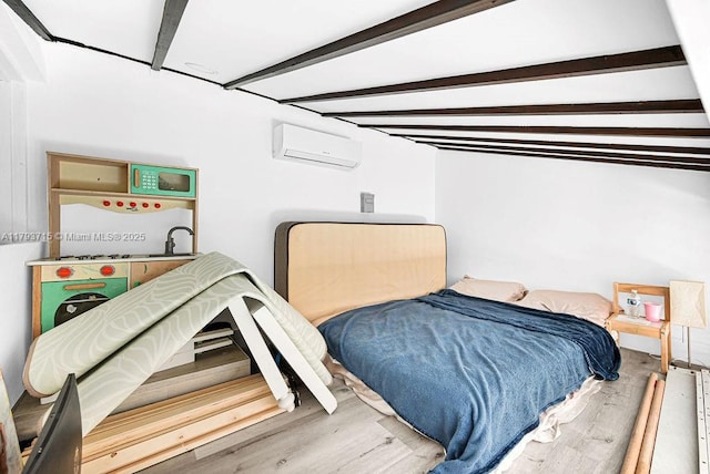 bedroom with a wall mounted AC and wood finished floors