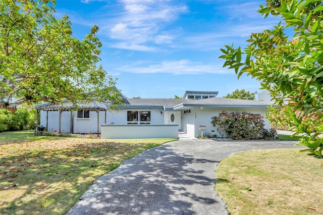 7600 SW 124th St, Pinecrest, FL 33156 - view of front facade with stucco siding, asphalt driveway, and a front lawn