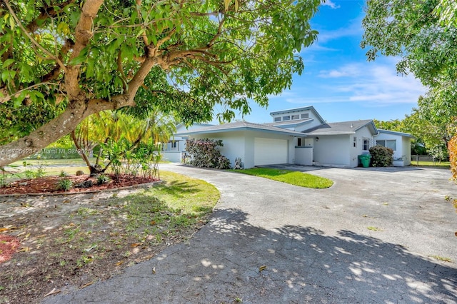 7600 SW 124th St, Pinecrest, FL 33156 - view of front of house featuring stucco siding, a garage, and driveway