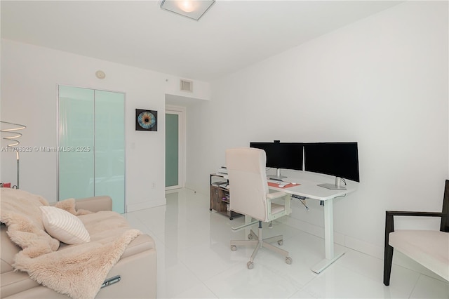 office area with tile patterned floors, visible vents, and baseboards