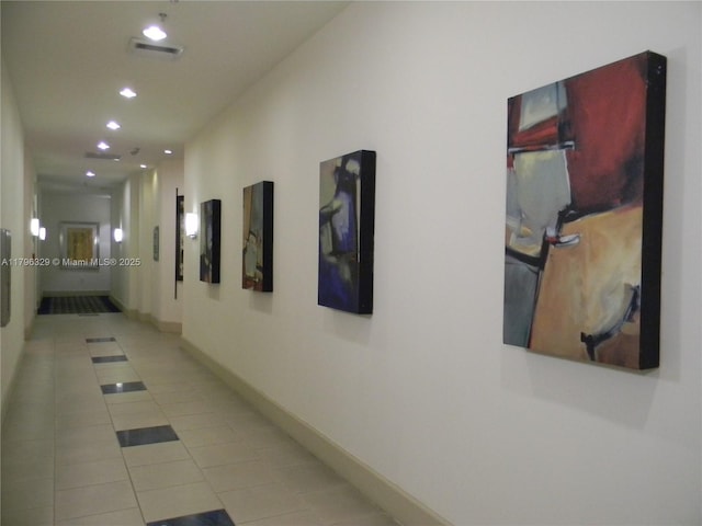 hallway with tile patterned flooring, baseboards, visible vents, and recessed lighting