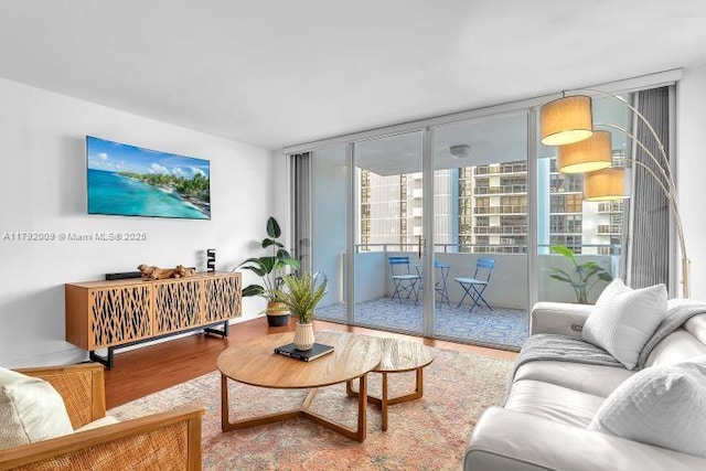 living area featuring baseboards, floor to ceiling windows, and wood finished floors