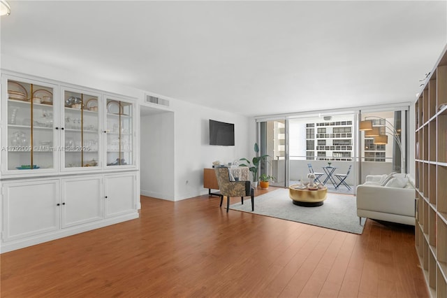 living room with wood finished floors, baseboards, and expansive windows