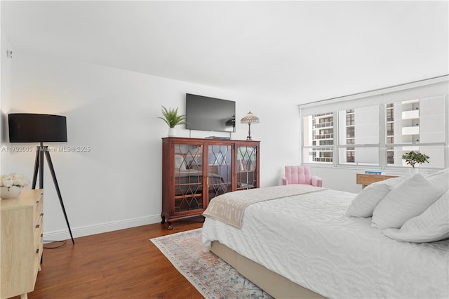 bedroom with wood finished floors and baseboards