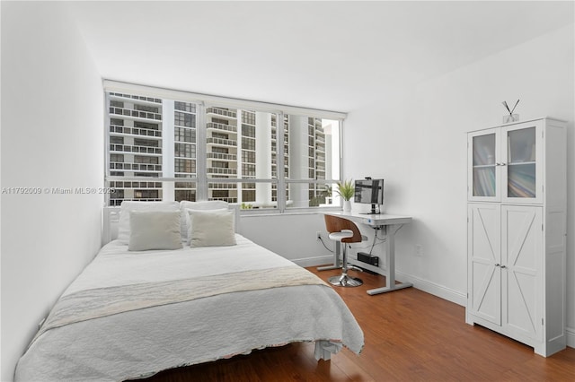 bedroom with wood finished floors and baseboards