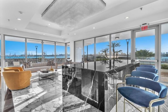 sunroom featuring a water view