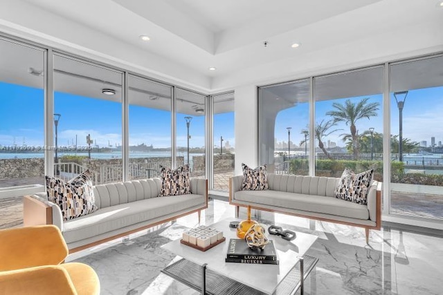 living area with a water view, marble finish floor, and recessed lighting