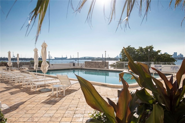 community pool featuring fence and a patio