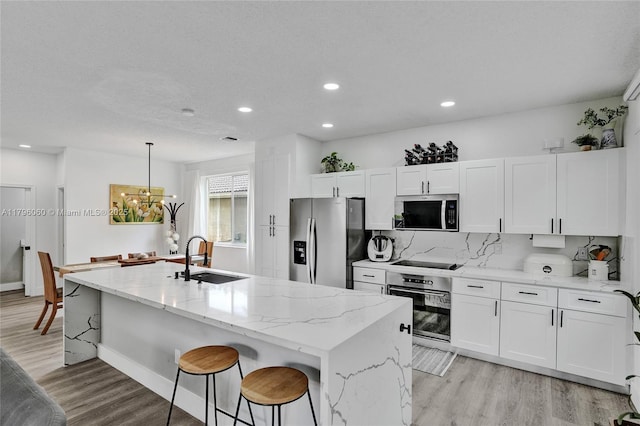 1381 Sago Ln, Weston, FL 33327 - kitchen featuring white cabinets, light wood-style floors, stainless steel appliances, and a sink
