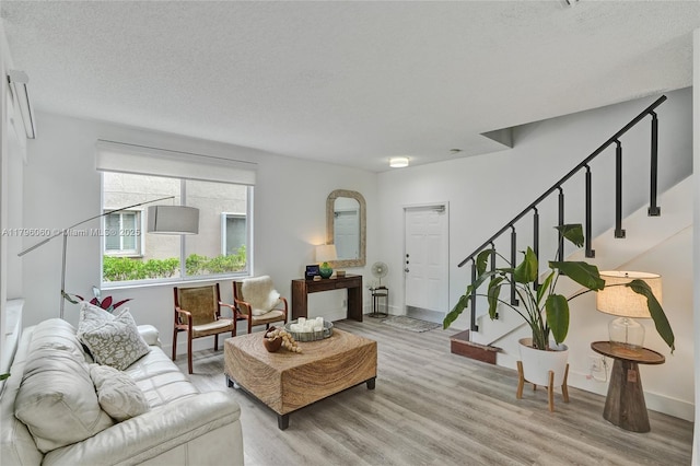 1381 Sago Ln, Weston, FL 33327 - living area featuring a textured ceiling, stairway, light wood-style flooring, and baseboards
