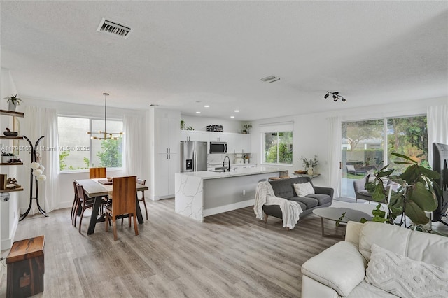1381 Sago Ln, Weston, FL 33327 - living room featuring recessed lighting, light wood-style floors, visible vents, and a notable chandelier