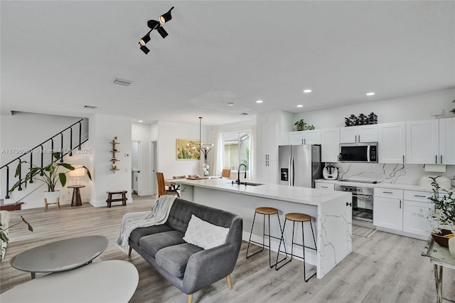 1381 Sago Ln, Weston, FL 33327 - kitchen featuring recessed lighting, a sink, white cabinetry, light wood-style floors, and appliances with stainless steel finishes