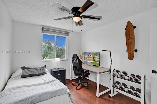 bedroom featuring a textured ceiling, wood finished floors, and ceiling fan