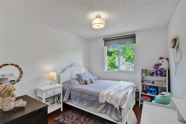 bedroom with a textured ceiling and dark wood-style floors