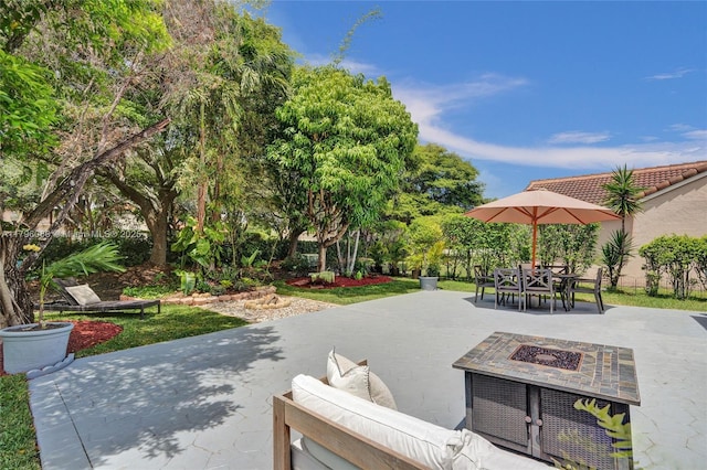 view of community with an outdoor fire pit, a patio, and outdoor dining space