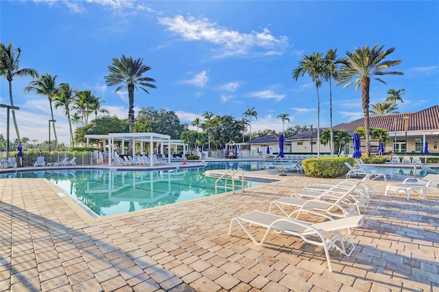 community pool with a patio and fence