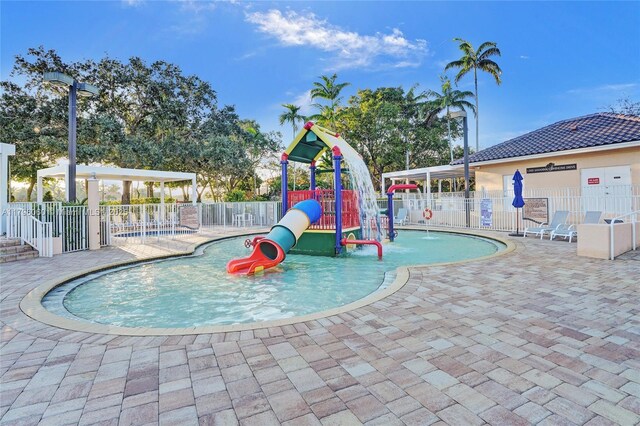 1381 Sago Ln, Weston, FL 33327 - communal playground with a water play area, fence, and a patio