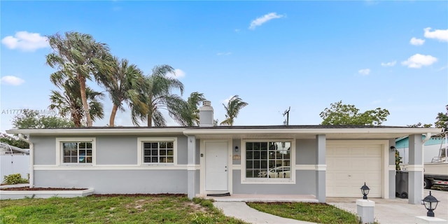 ranch-style house featuring stucco siding, driveway, a chimney, and a garage