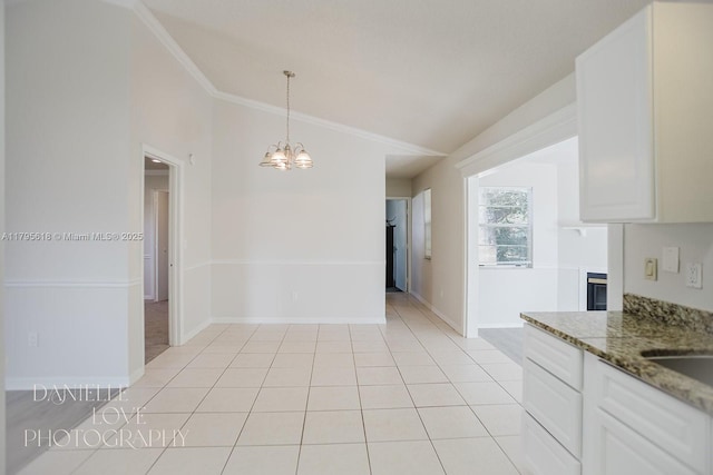 557 NW Fairfax Ave, Port St Lucie, FL 34983 - interior space with light tile patterned floors, baseboards, an inviting chandelier, crown molding, and vaulted ceiling