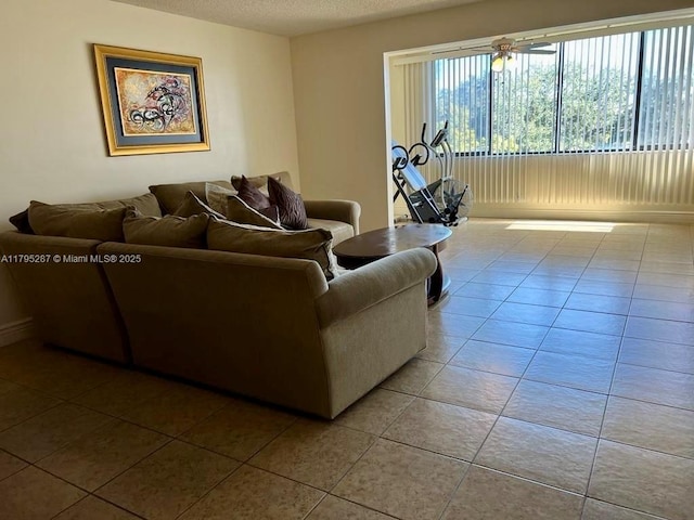 living area featuring a textured ceiling, a ceiling fan, and tile patterned floors