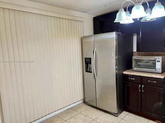 kitchen featuring decorative light fixtures, stainless steel refrigerator with ice dispenser, a toaster, an inviting chandelier, and light tile patterned floors