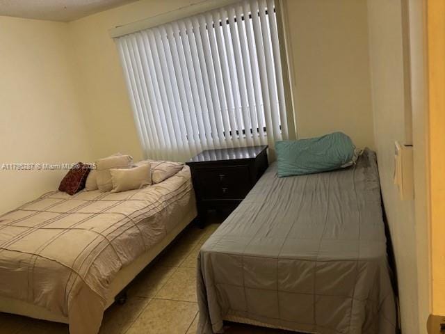 bedroom with multiple windows and tile patterned flooring