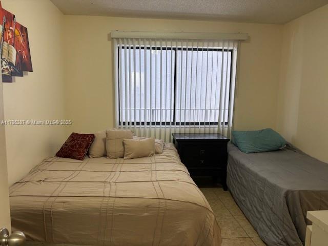 bedroom featuring light tile patterned floors and multiple windows