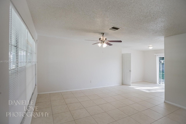 unfurnished room with light tile patterned floors, visible vents, a ceiling fan, and a textured ceiling