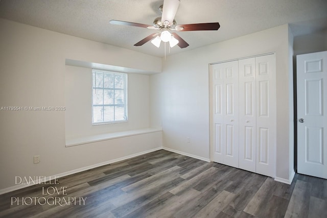 unfurnished bedroom featuring baseboards, a closet, a ceiling fan, and dark wood-style floors