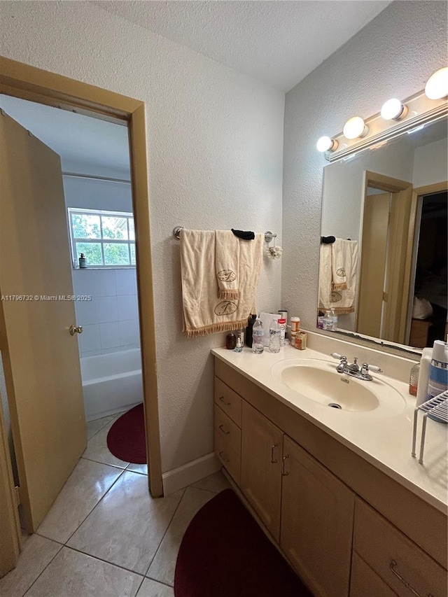 full bath with vanity, a textured ceiling, a textured wall, and tile patterned floors