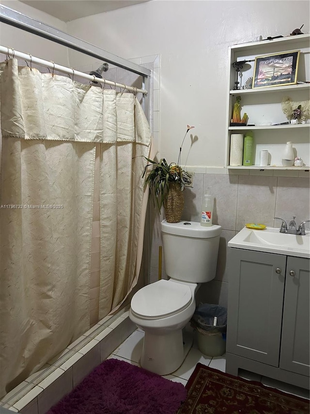 bathroom featuring tile patterned floors, vanity, toilet, and a shower stall