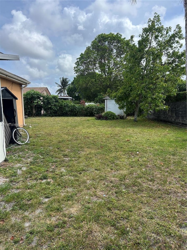 view of yard with fence, a storage shed, and an outdoor structure