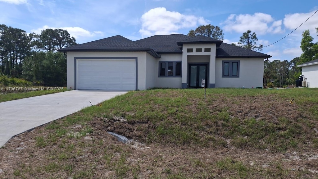 3501 W 70th St W, Lehigh Acres, FL 33971 - prairie-style house with stucco siding, driveway, an attached garage, and roof with shingles