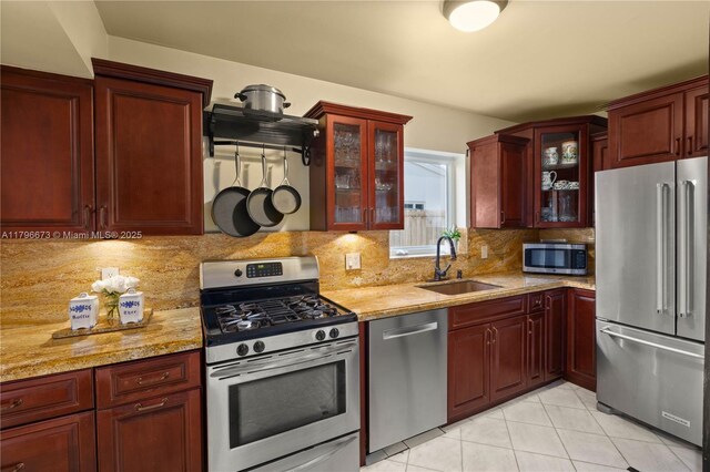 9033 SW 78th Pl, Miami, FL 33156 - kitchen featuring stainless steel appliances, a sink, dark brown cabinets, light tile patterned flooring, and backsplash