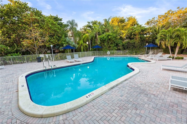 9033 SW 78th Pl, Miami, FL 33156 - community pool featuring fence, a patio area, and view of scattered trees