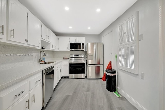 1301 NE 191st St Unit F417, Miami, FL 33179 - kitchen featuring stainless steel appliances, baseboards, light wood finished floors, a sink, and light countertops