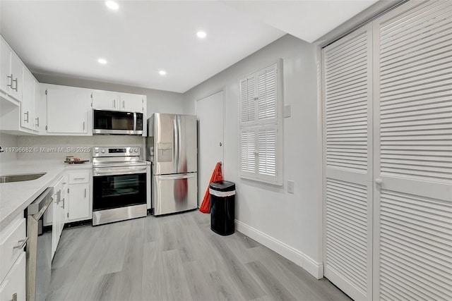 1301 NE 191st St Unit F417, Miami, FL 33179 - kitchen featuring a sink, stainless steel appliances, light wood-type flooring, baseboards, and light countertops