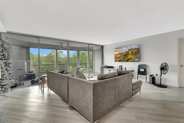 1301 NE 191st St Unit F417, Miami, FL 33179 - living area featuring baseboards, a wall of windows, light wood-style floors, and a ceiling fan